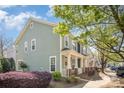 Well-maintained townhome features mature landscaping, green siding, and inviting front porches at 464 Hurston Cir, Charlotte, NC 28208