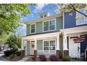 Charming townhome with a covered front porch, white trim, and a beautifully landscaped yard at 464 Hurston Cir, Charlotte, NC 28208