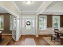 Inviting home entryway featuring wood floors, a decorative wreath, and bright natural light at 5140 Oak Grove Pl, Waxhaw, NC 28173