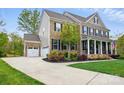 Spacious home showcasing a three-car garage, brick facade, and lush landscaping on a sunny day at 5140 Oak Grove Pl, Waxhaw, NC 28173