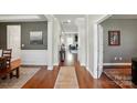 Elegant hallway with hardwood floors, neutral paint, and decorative trim showcasing an open floor plan at 5140 Oak Grove Pl, Waxhaw, NC 28173