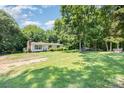 A quaint single-story home sits on a lush, tree-filled lot, offering a peaceful and private setting at 5275 Long Ferry Rd, Salisbury, NC 28146