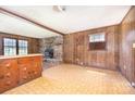 Rustic living room with wood paneling, a stone fireplace, and a unique built-in cabinet at 5275 Long Ferry Rd, Salisbury, NC 28146