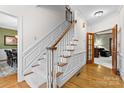 Elegant staircase featuring hardwood steps, white risers, and detailed trim at 5309 Silchester Ln, Charlotte, NC 28215