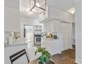 Bright kitchen with stainless steel appliances, stone countertops, white cabinetry, and dine-in table at 5909 Quail Hollow Rd # B, Charlotte, NC 28210