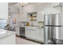 Well-lit kitchen features stainless steel refrigerator, white cabinets, stone countertops, and dine-in table at 5909 Quail Hollow Rd # B, Charlotte, NC 28210