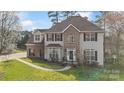 Beautiful two-story home with brick accents, well-maintained lawn, mature trees, and charming curb appeal at 7510 Plumcrest Ln, Harrisburg, NC 28075