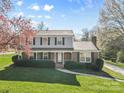 Inviting two-story home showcasing a well-kept lawn, brick accents, and a cozy covered porch at 9218 Robert Burns Ct, Charlotte, NC 28213