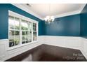 Bright dining room with large windows, dark wood floors, and teal accent wall at 128 Millen Dr, Mooresville, NC 28115