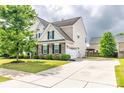 View of a two-story home featuring an attached garage and a well-maintained front yard at 128 Millen Dr, Mooresville, NC 28115