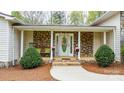 A welcoming front porch with stone accents, pillars, and a 'Welcome' sign at 1514 Ring Tail Rd, Claremont, NC 28610