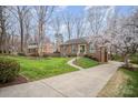 Beautiful brick home with well-manicured lawn, mature trees and long driveway at 15920 Fieldstone Dr, Matthews, NC 28104