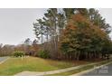 A glimpse of the charming house exterior through the autumn trees on a large lot at 2013 Garden View Ln, Weddington, NC 28104