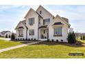 Charming two-story home with manicured lawn, brick facade and black trim on windows and eaves at 2013 Garden View Ln, Weddington, NC 28104