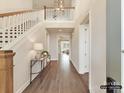 Bright foyer with hardwood floors, soaring ceilings, grand staircase and modern chandelier at 2013 Garden View Ln, Weddington, NC 28104