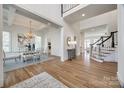Open floor plan with hardwood floors, high ceilings, and chandelier-lit dining area and staircase at 2622 Sheffield Crescent Ct, Charlotte, NC 28226