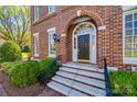 Elegant home entrance with arched brick, black door, decorative sidelights and stone steps at 2622 Sheffield Crescent Ct, Charlotte, NC 28226