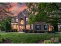 Charming brick home with well-lit facade and manicured lawn at twilight at 3017 Chisholm Ct, Waxhaw, NC 28173