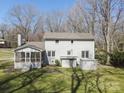 View of the back exterior with a screened-in porch, an additional utility shed and a nice, green lawn at 306 7Th Street Ne Pl, Conover, NC 28613