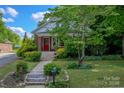 Inviting home exterior with a bright red door and manicured landscaping at 312 Gold Hill Ave, Rockwell, NC 28138