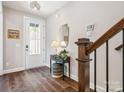 Welcoming foyer featuring hardwood floors, a decorative table, and stairs leading to the upper level at 403 Old Town Village Rd, Waxhaw, NC 28173