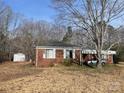 Classic red brick house with a car port and mature trees against a bright blue sky, located near an outbuilding at 501 Neelys Creek Rd, Rock Hill, SC 29730