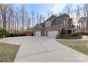 Long driveway leads to a three-car garage, offering ample parking and a side view of the home's exterior at 518 May Green Dr, Clover, SC 29710