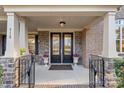 Elegant double front doors are flanked by stone columns and flower planters, creating a welcoming entrance at 518 May Green Dr, Clover, SC 29710