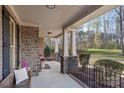 Inviting covered front porch with decorative stone columns and black iron railing, perfect for relaxing outdoors at 518 May Green Dr, Clover, SC 29710