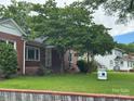 Charming brick home with mature trees and a well-maintained lawn and 'For Sale' sign at 603 E Main St, Rock Hill, SC 29730