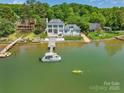 Waterfront property with boat dock, boat, and home nestled among lush trees at 8150 Malibu Pointe Ln, Denver, NC 28037