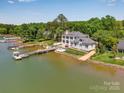 Waterfront home with lush trees, boat dock with boat on the calm waters at 8150 Malibu Pointe Ln, Denver, NC 28037