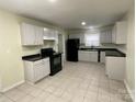 Bright kitchen features neutral cabinets, black appliances, and tile flooring at 837 Corwin Dr, Charlotte, NC 28213