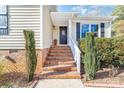 Inviting front door entrance with brick steps, white railings, and black shutters at 9624 Buckskin Ln, Mint Hill, NC 28227