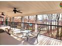 Covered porch featuring seating with a view of the surrounding trees and lake at 112 Trestle Cir, New London, NC 28127