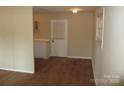 View of a room with a doorway, light beige walls, door to the backyard and wood flooring at 1138 Choyce Ave, Charlotte, NC 28217