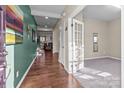 Inviting foyer featuring hardwood floors, a view of the stairs and living room, and a carpeted office at 12302 Volusia Ct, Charlotte, NC 28262