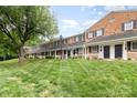 Scenic view of well-maintained townhomes with lush green lawn and mature shade tree at 1310 Green Oaks Ln # H, Charlotte, NC 28205