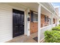 Close-up of a front porch highlighting the brick facade, black door, and white trim at 1310 Green Oaks Ln # H, Charlotte, NC 28205