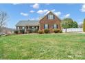 Charming brick home featuring a well-manicured lawn, classic shutters, and a welcoming front porch at 1529 Indian Springs Nw Dr, Conover, NC 28613