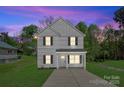 Charming two-story home featuring a welcoming porch, manicured lawn and exterior lighting at 1611 Carlton Ave, Kannapolis, NC 28083