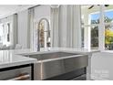Close-up of a stainless steel farmhouse sink under a window showing the outdoors at 2133 Moss Bluff Dr, Mint Hill, NC 28227