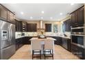 Modern kitchen featuring dark cabinets, granite countertops, stainless steel appliances, and a center island at 226 Hermance Ln, Mooresville, NC 28117
