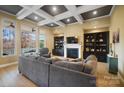 Elegant living room featuring coffered ceilings, a fireplace, built-in shelving, and large windows overlooking picturesque views at 226 Hermance Ln, Mooresville, NC 28117