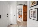 Inviting foyer with wood floors, decorative sliding barn door, and neutral paint at 230 Pond View Ln, Fort Mill, SC 29715