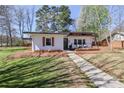 Quaint home with a lush green lawn, walkway, and inviting front porch, creating an appealing exterior at 324 East End S Ave, Statesville, NC 28677