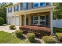 Charming front porch with a seating area, lush bushes, and well-maintained landscaping enhances curb appeal at 352 Nantucket Way, Rock Hill, SC 29732