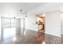 Sunlit living room offering hardwood floors and seamless transition to the kitchen at 3960 Town Center Rd, Harrisburg, NC 28075