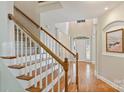 Open foyer showcasing hardwood floors, staircase with white railings, and an arched entryway at 6008 Nuthatch Ct, Charlotte, NC 28277