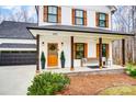 Inviting front porch with a wooden bench, stylish decor, and an eye-catching wood front door at 693 Luther Dr, Iron Station, NC 28080